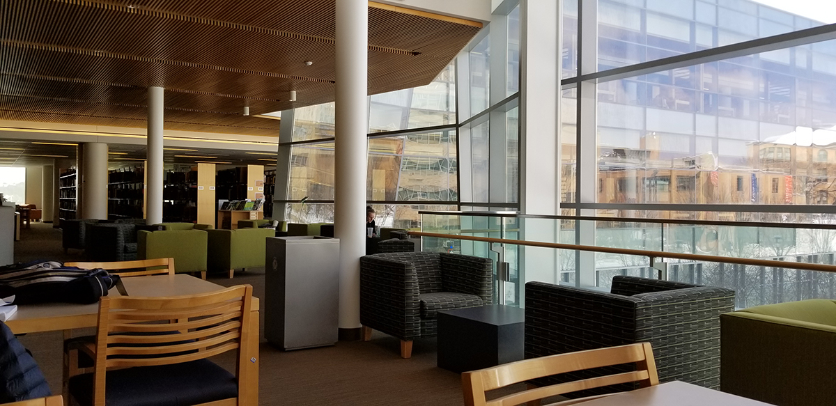 interior of modern library—windows, tables and armchairs