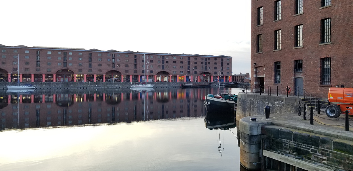 view across water to large, low brick building
